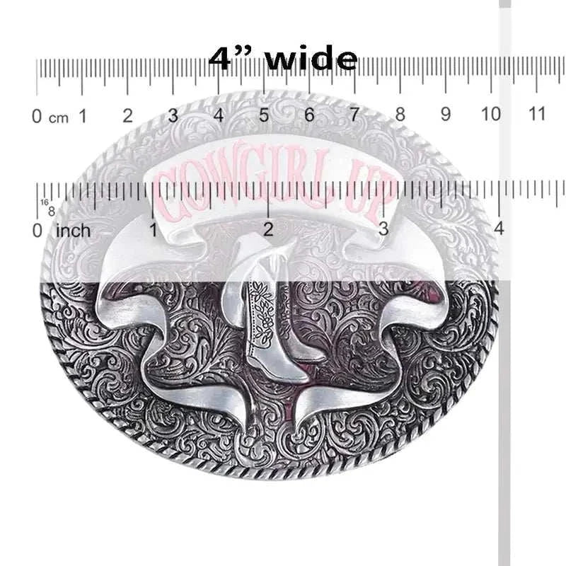 Pink Cowgirl Up belt buckle with cowboy boots design and intricate floral engraving, measuring 4 inches wide.