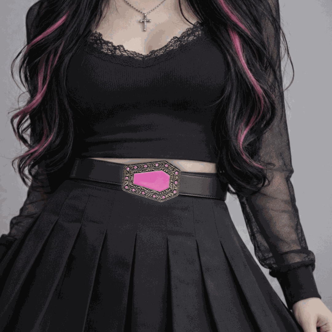 Girl wearing a black outfit with a pink belt buckle against a gray background