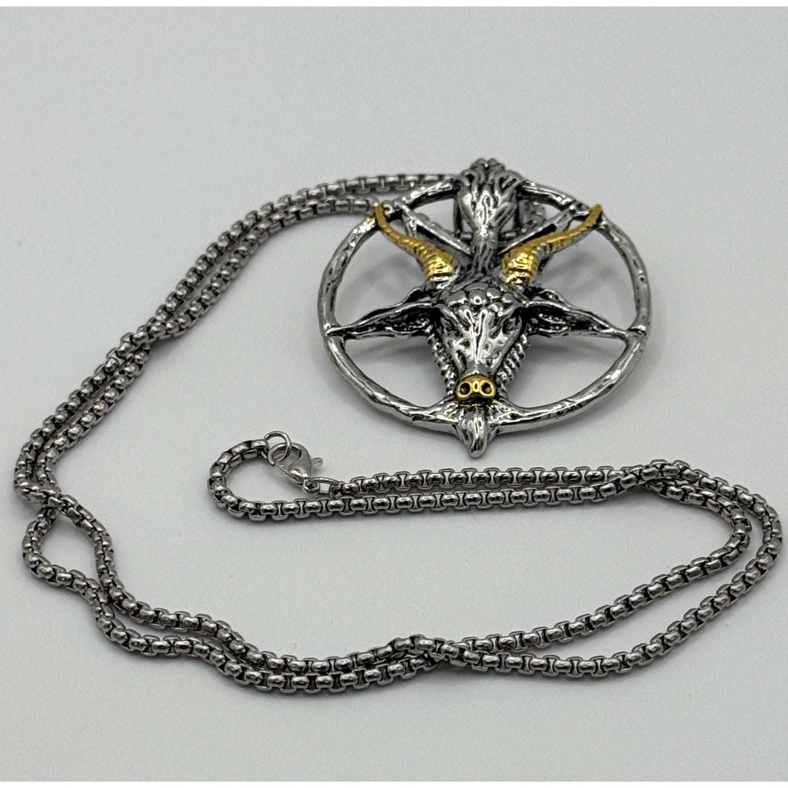 TornSlayer Goat Head Pentagram Necklace with silver and gold goathead pendant and 22-inch chain.