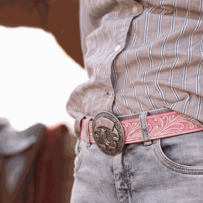 Person wearing a patterned shirt, jeans, and a pink belt with a decorative buckle.