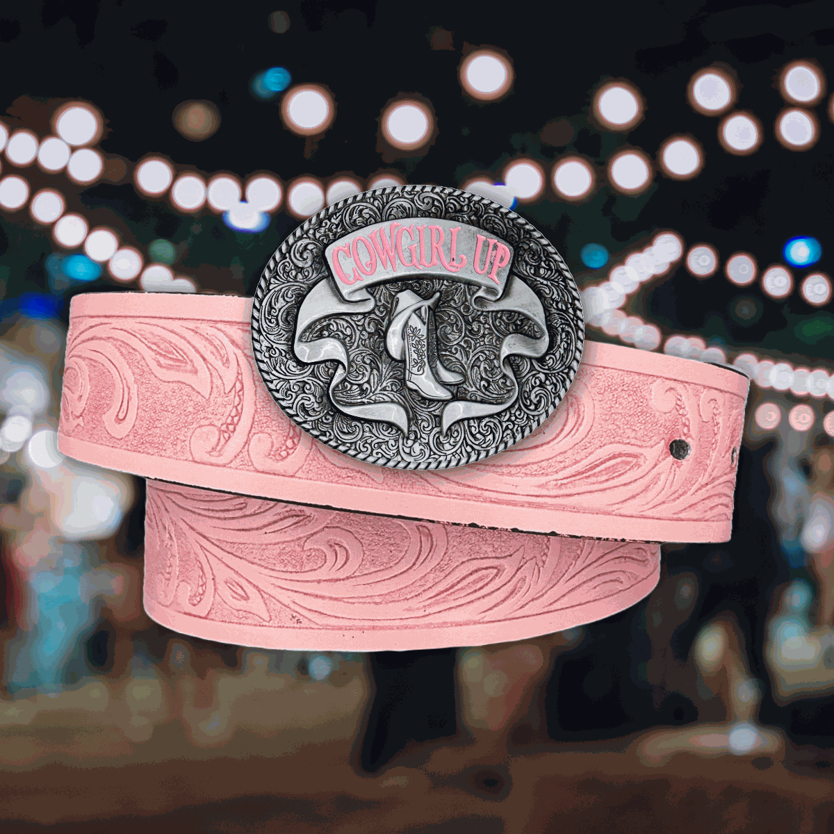 Pink cowgirl up belt with silver buckle featuring embossed scrollwork and cowboy boots.